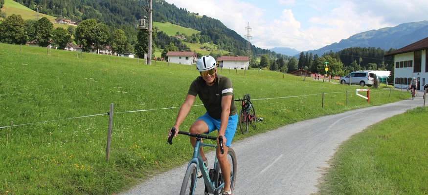 Graveln im Brixental © Michael Küchl Fahrradfahrer auf Landstraße in ländlicher Alpenlandschaft