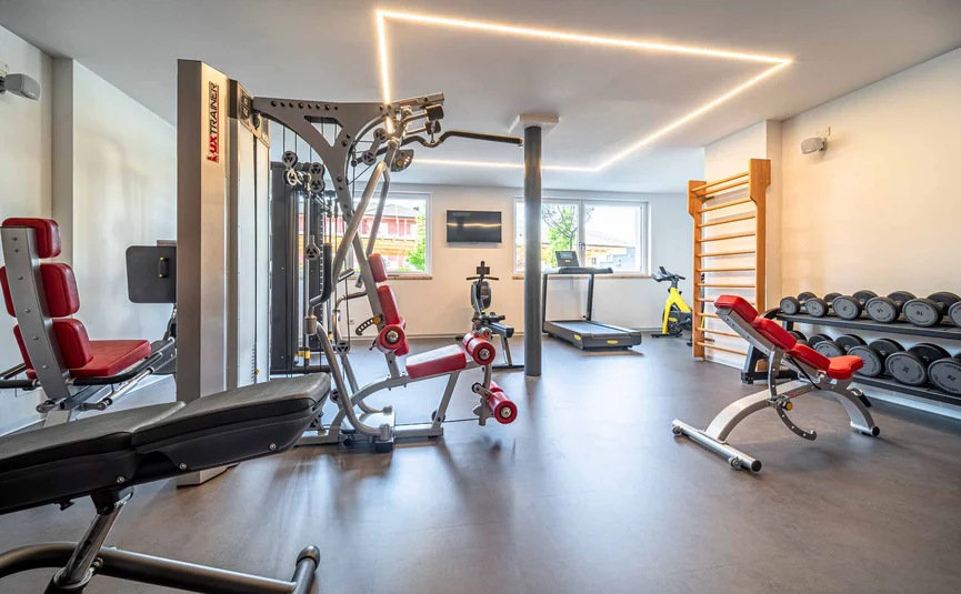 Cristallo Sport & Wellness Hotel **** © Andrea Acler Modern gym equipment with dumbbells, treadmill, and workout machines