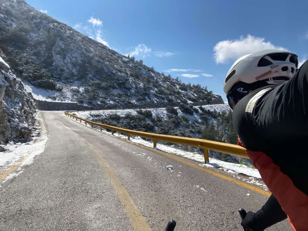 Bikepacking von Wien nach Athen © Jan Koller Radfahrer auf verschneiter Bergstraße bei klarem Himmel