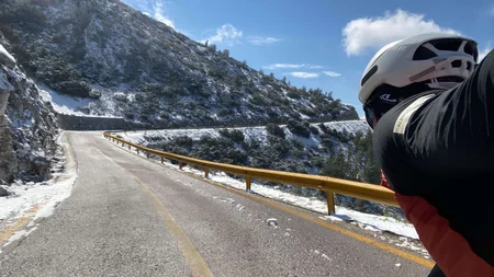 Bikepacking von Wien nach Athen © Jan Koller Radfahrer auf verschneiter Bergstraße bei klarem Himmel