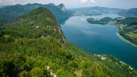 Drei Seen, eine Gravelrunde: Die 3-Seen-Tour ab Fuschl © Erwin Haiden Blick auf grünen Wald und blauen Bergsee unter bewölktem Himmel