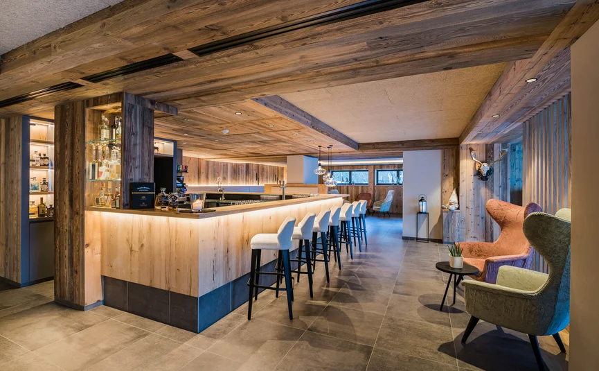 Modern bar area with wooden paneling and high stools