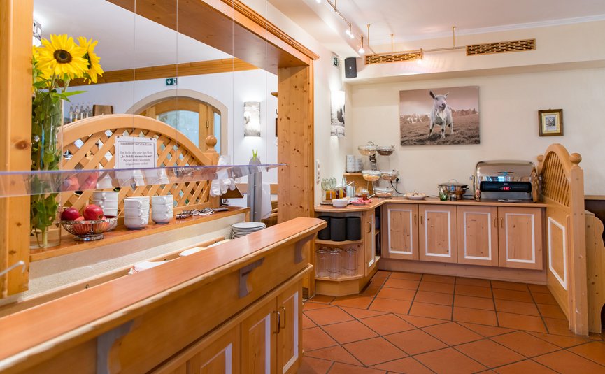 Gemütlicher Frühstücksbereich mit Holztheke und Buffet