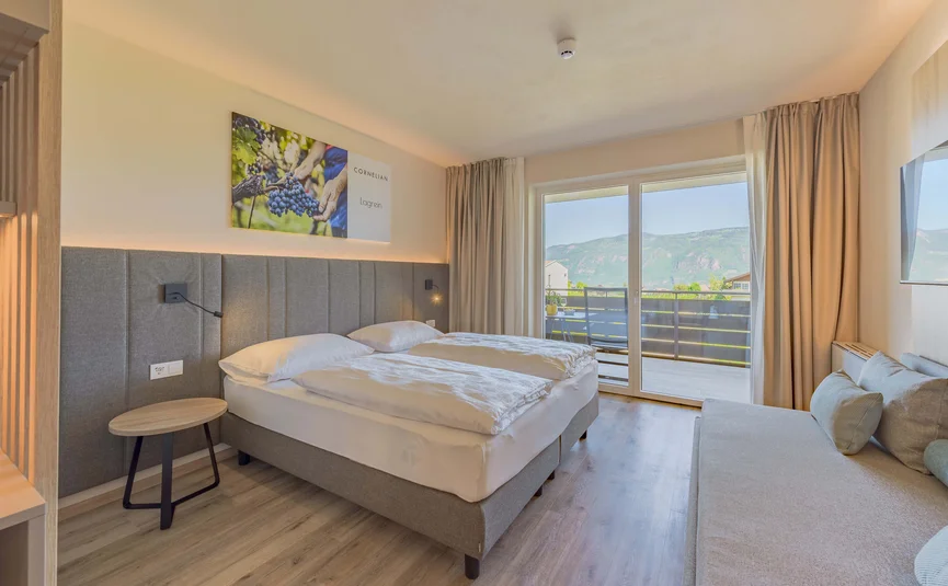 Modern bedroom with double bed and balcony offering mountain views