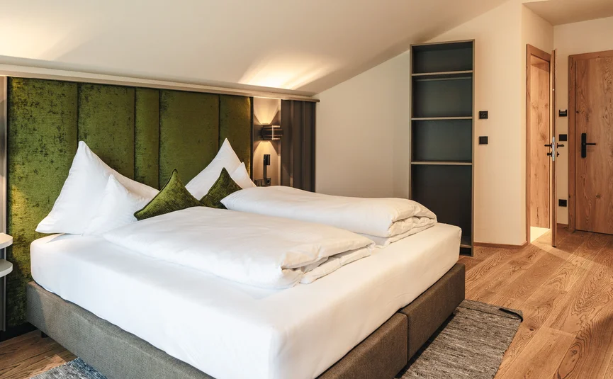 Modern bedroom with green headboard and white bedding