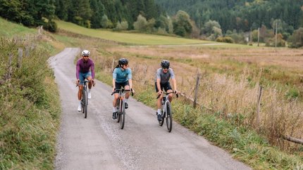 Steinbichl-Gurktal © Martin Hoffmann Drei Radfahrer fahren auf einem Landweg durch eine bewaldete Berglandschaft