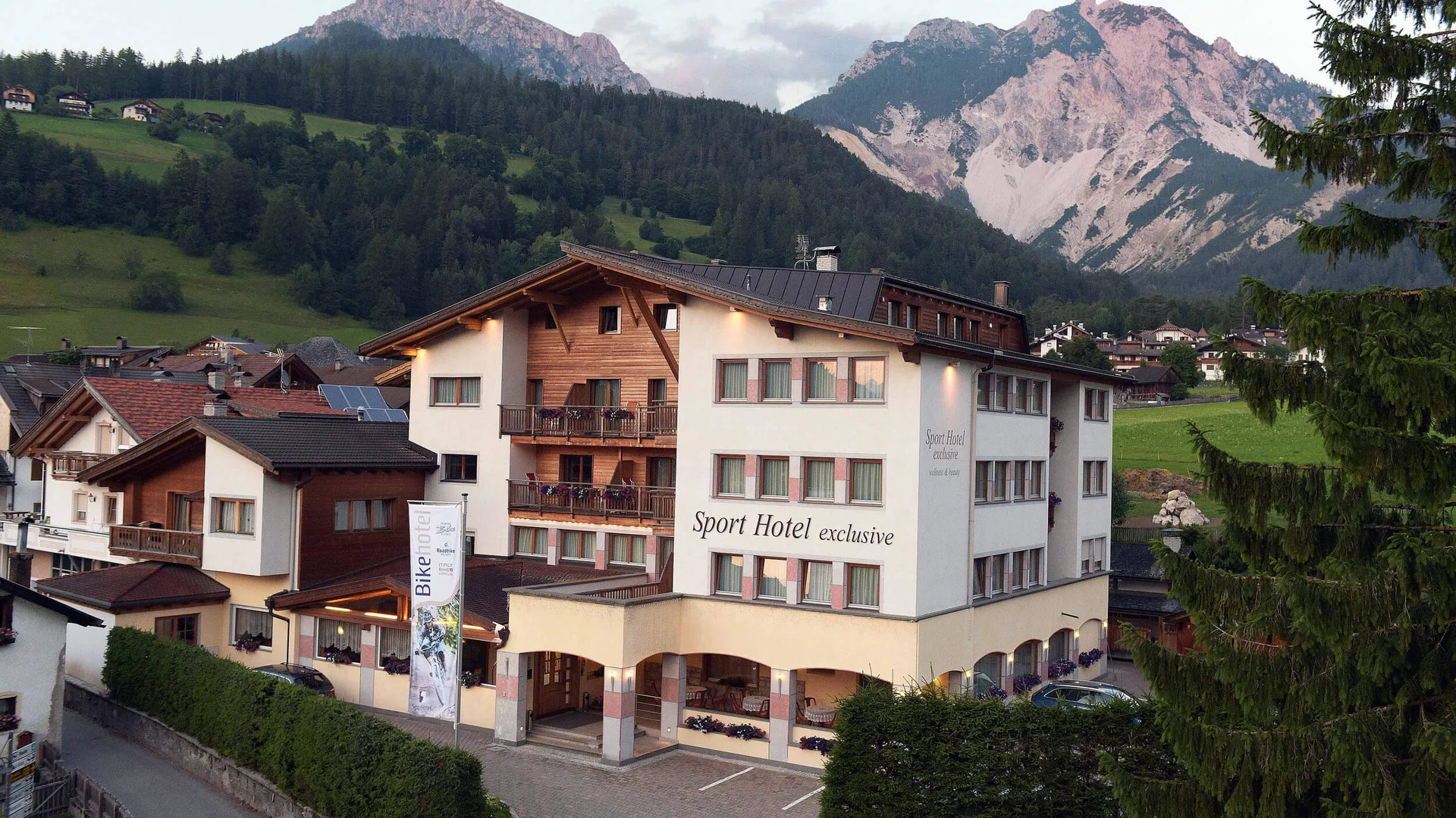 Sport Hotel in Berglandschaft mit Tannenzapfen und Bergen im Hintergrund