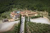 Aerial view of a countryside villa with cypress-lined driveway