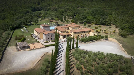 Aerial view of a countryside villa with cypress-lined driveway