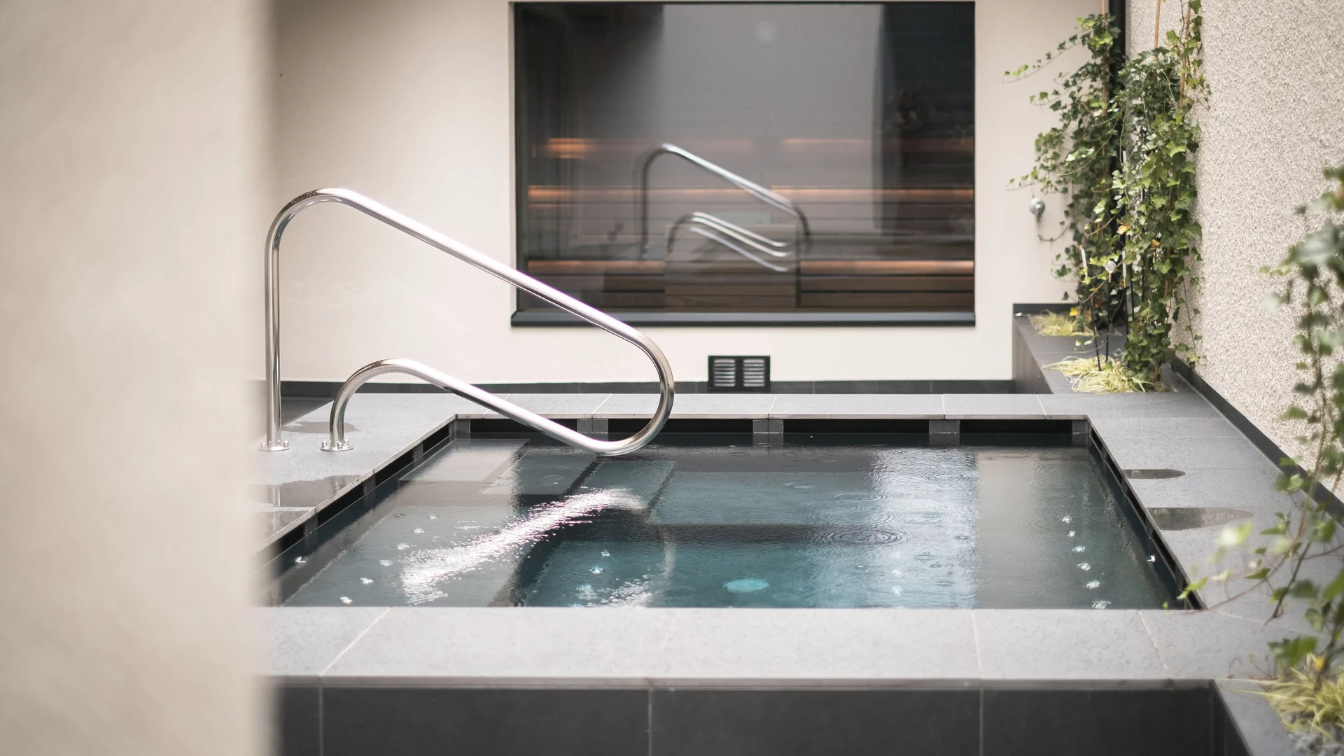 Neue Gravelbike Holidays Hotels 2026 © Lunah Photography - Lukas Haberer & Hannah Beikircher Moderner Whirlpool mit Edelstahlgeländer und Pflanzenwand