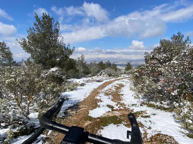 Bikepacking von Wien nach Athen © Jan Koller Fahrradlenker auf schneebedecktem Waldweg unter blauem Himmel