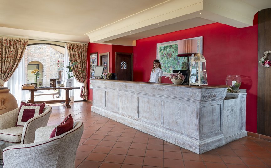 Hotel & Restaurant Casolare Le Terre Rosse ***S © Hotel Casolare Le Terre Rosse Hotelrezeption mit einer Empfangsdame hinter dem Tresen