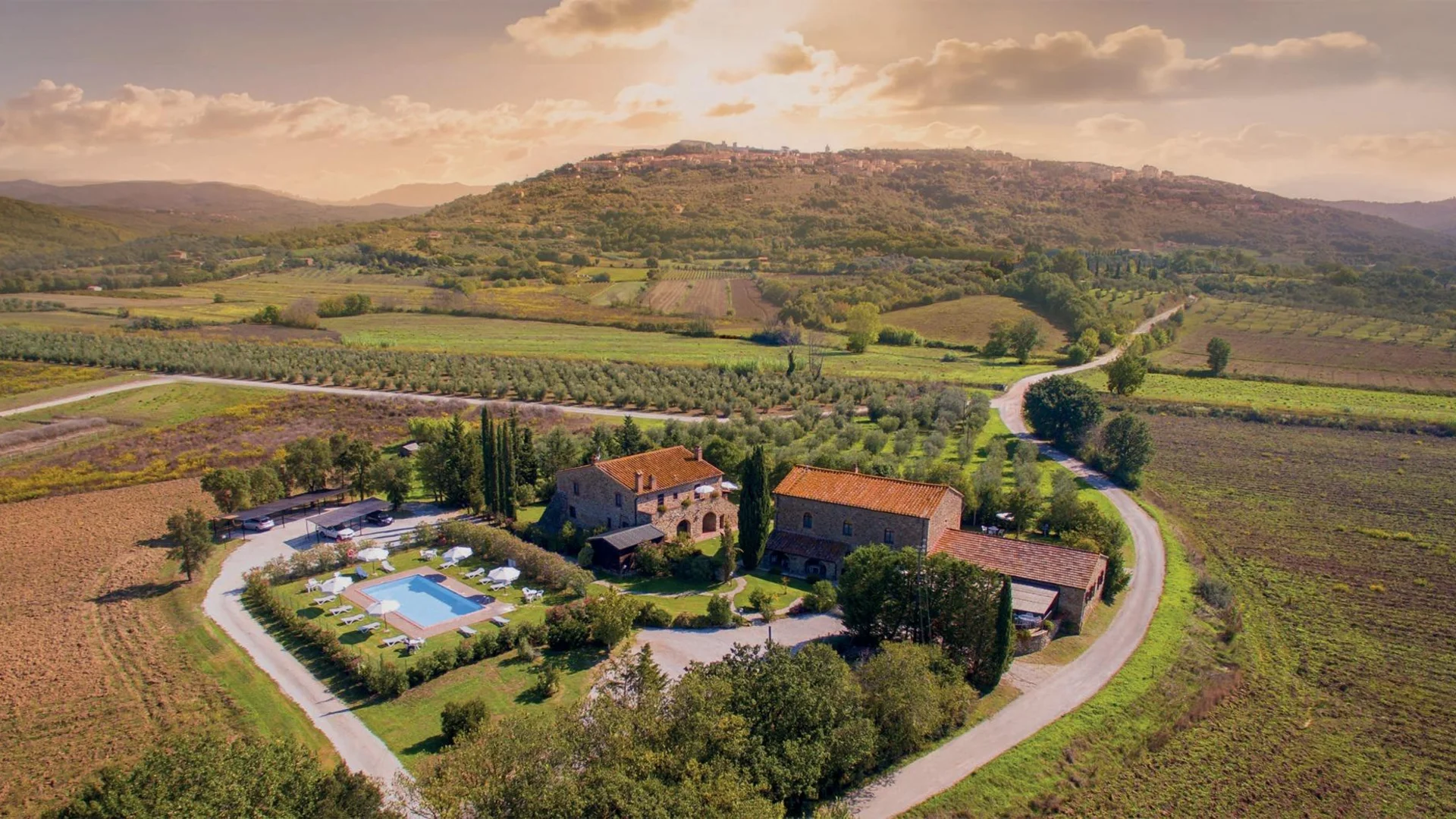 Gravelbiken in der Toskana © Tenuta il Cicalino Luftaufnahme eines Bauernhauses mit Pool in einer grünen Hügellandschaft