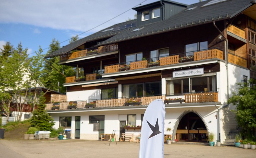 Außenansicht des Landhotels Fuchs mit Balkon und weißer Werbefahne