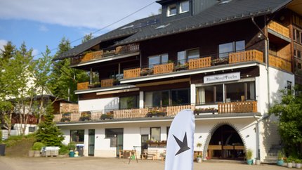 Außenansicht des Landhotels Fuchs mit Balkon und weißer Werbefahne