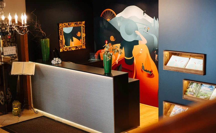 Reception desk with wall art and lighting in a hotel lobby