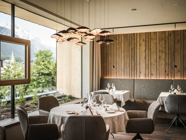 Herbst auf Schotter im Excelsior Dolomites Life Resort****s © Hannes Niederkofler Elegantes Restaurant mit Bergblick und modernem Holzdesign
