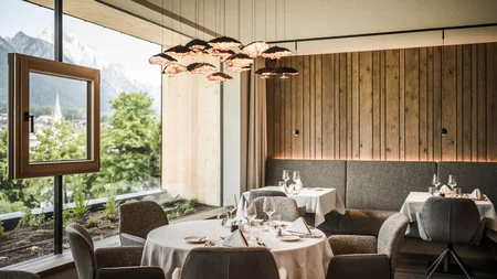 Herbst auf Schotter im Excelsior Dolomites Life Resort****s © Hannes Niederkofler Elegantes Restaurant mit Bergblick und modernem Holzdesign
