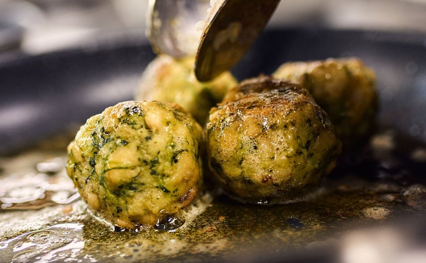Spinatbällchen werden in einer Pfanne mit Öl gebraten