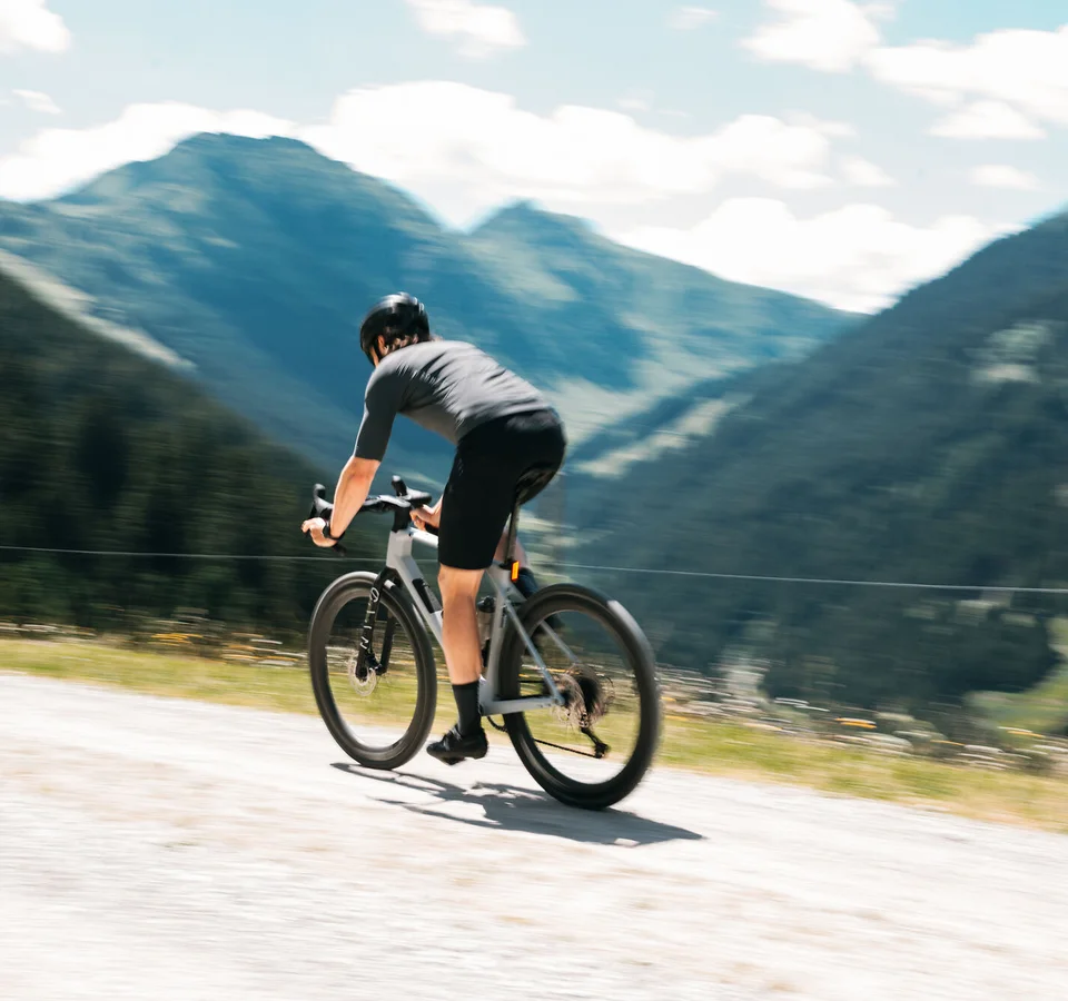 Graveln in den Kitzbüheler Alpen © Martina Wunderle / Flo Distl Fahrradfahrer auf Bergstraße mit Bergen im Hintergrund
