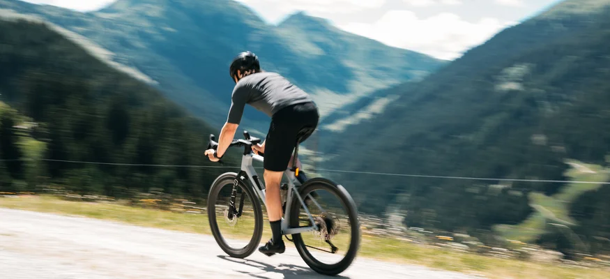 Graveln in den Kitzbüheler Alpen © Martina Wunderle / Flo Distl Fahrradfahrer auf Bergstraße mit Bergen im Hintergrund