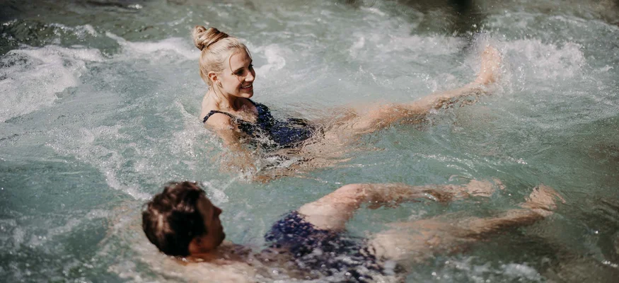 Zwei Personen entspannen sich im sprudelnden Wasser eines Pools