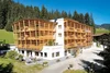 Hotel Melodia del Bosco with wooden balconies in a mountain forest setting