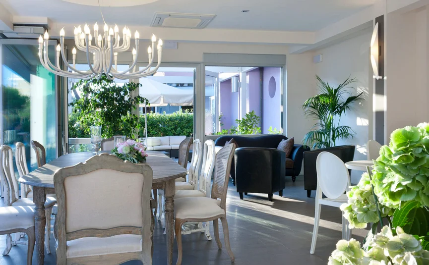 Moderner Essbereich mit Holztisch, Stühlen, Pflanzen und Ledersesseln