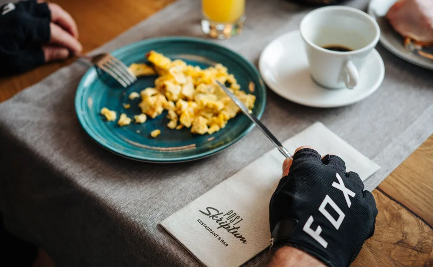 Frühstück mit Rührei, Brötchen, Orangensaft und Kaffee auf einem Tisch