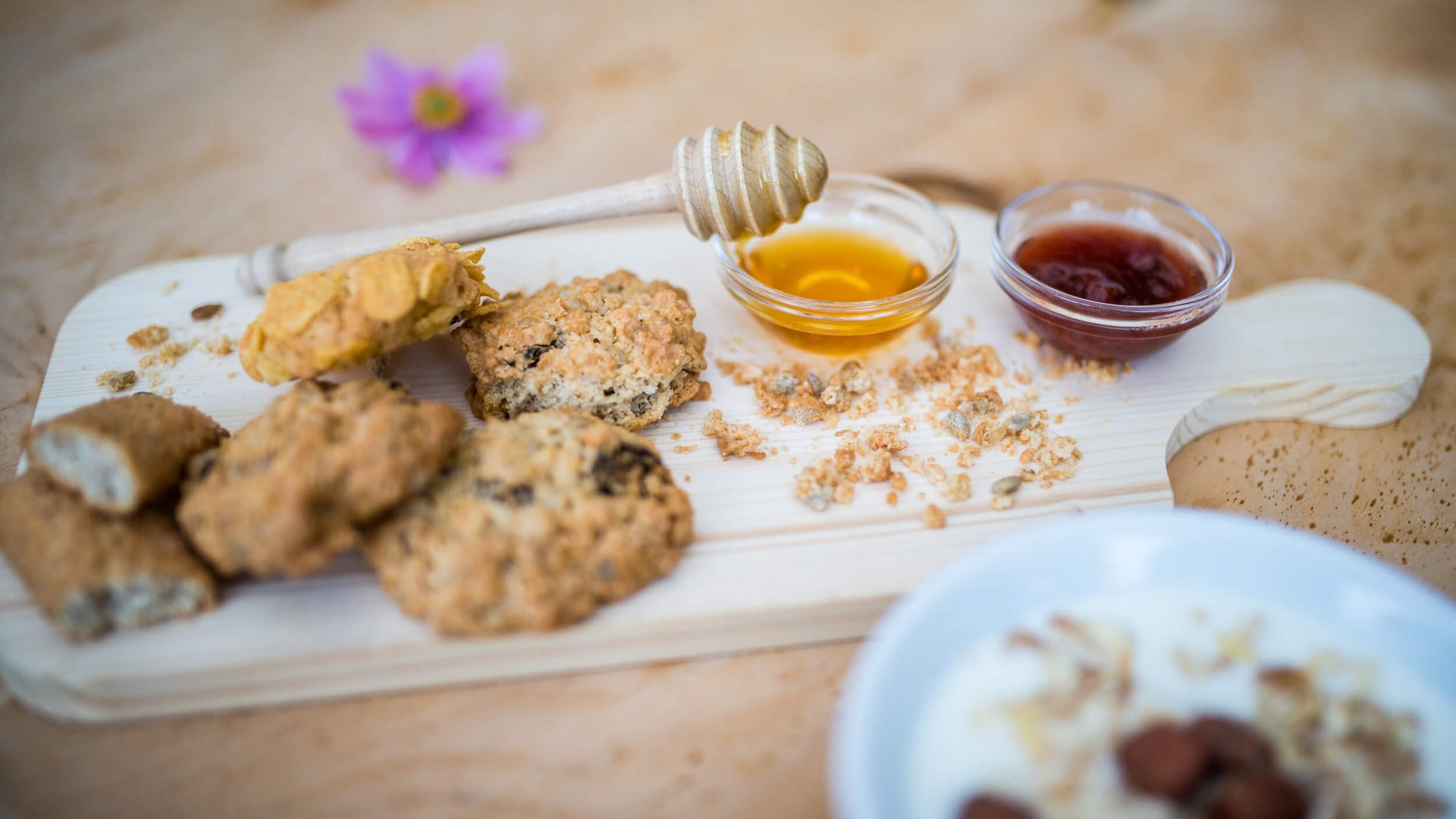 Kekse mit Honig und Marmelade auf einem Holzbrett