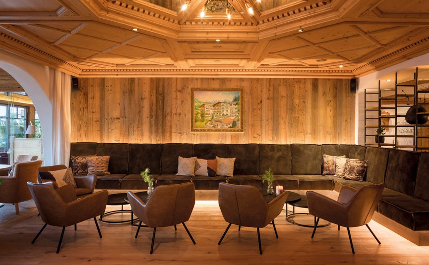 Gemütliche Sitzecke mit Ledersesseln und Holzdecke in warmem Licht