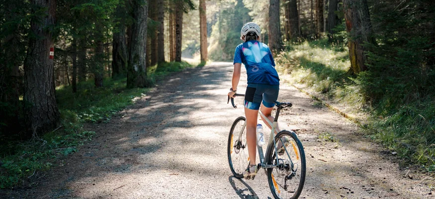 Ab ins Gelände! Vom Rennrad aufs Gravelbike © Josef Plaickner Radfahrer auf Waldweg bei Sonnenschein