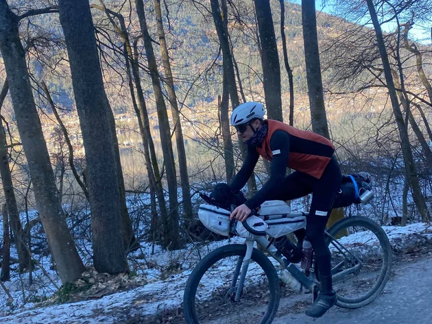 Bikepacking von Wien nach Athen © Jan Koller Radfahrer auf einem Waldweg im Winter mit Bergen im Hintergrund