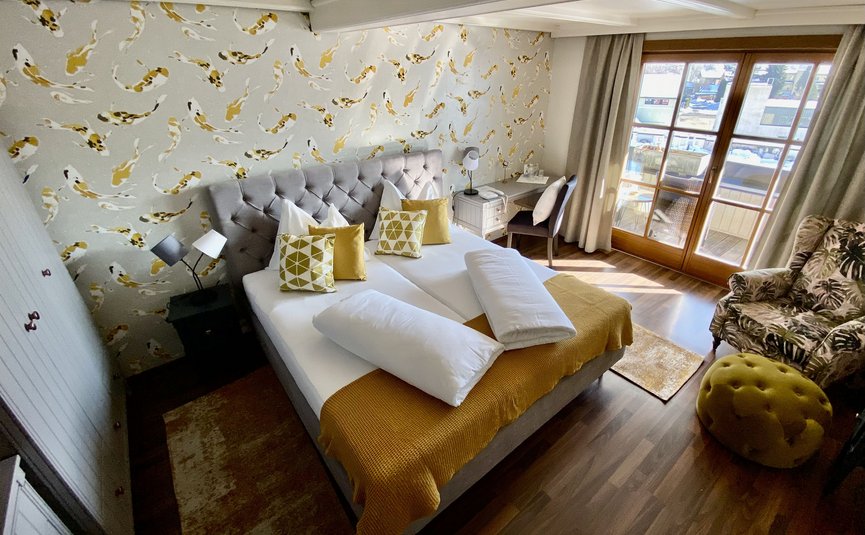 Cozy bedroom with yellow accents and large window to balcony