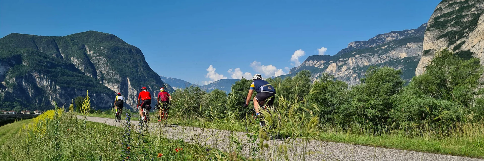 Radfahrer auf einem Weg mit Bergen und blauem Himmel im Hintergrund