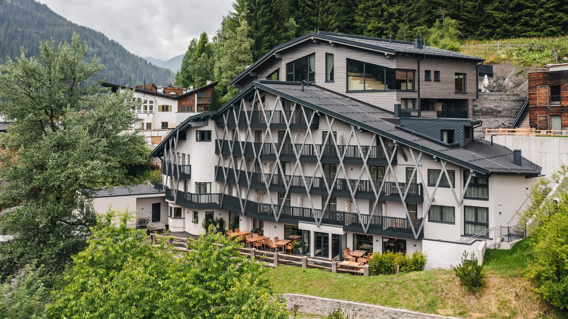 Modernes Hotel in den Bergen mit Terrasse und dichter Begrünung