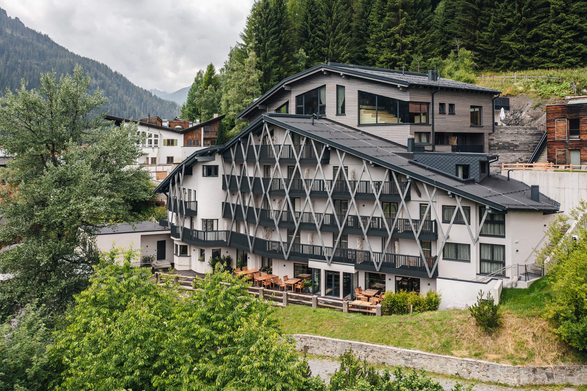 Modernes Hotel in den Bergen mit Terrasse und dichter Begrünung