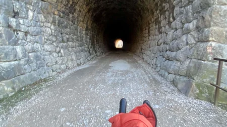 Bikepacking von Wien nach Athen © Jan Koller Blick von Fahrradlenker auf einen dunklen Steintunnel mit Licht am Ende