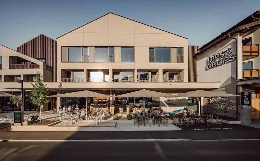 Außenansicht von Dips & Drops Bistro mit Terrasse und Gästen bei Sonnenlicht