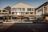 Exterior of Dips & Drops bistro with terrace and guests in sunlight