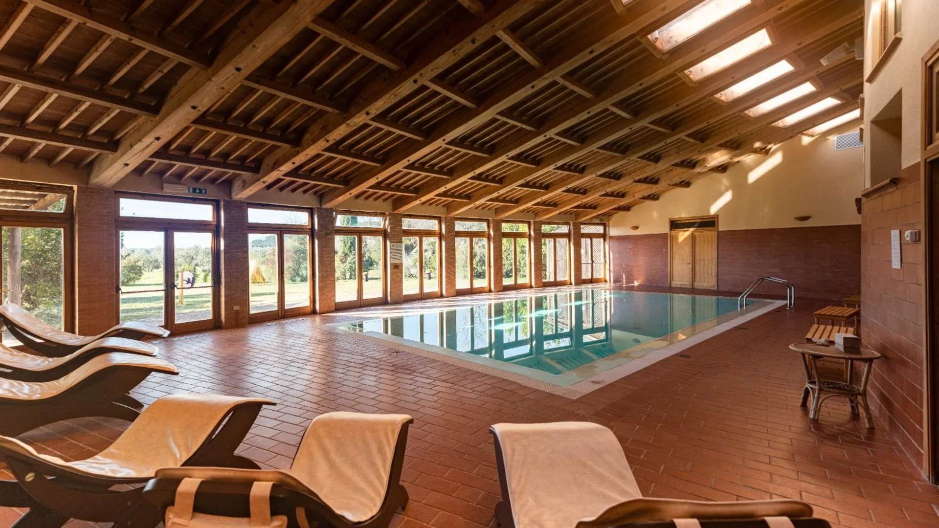 Gravelbiken in der Toskana © Tenuta il Cicalino Innenansicht eines Schwimmbads mit Holzdecke und Liegestühlen