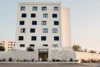Modern white hotel building facade with black window design