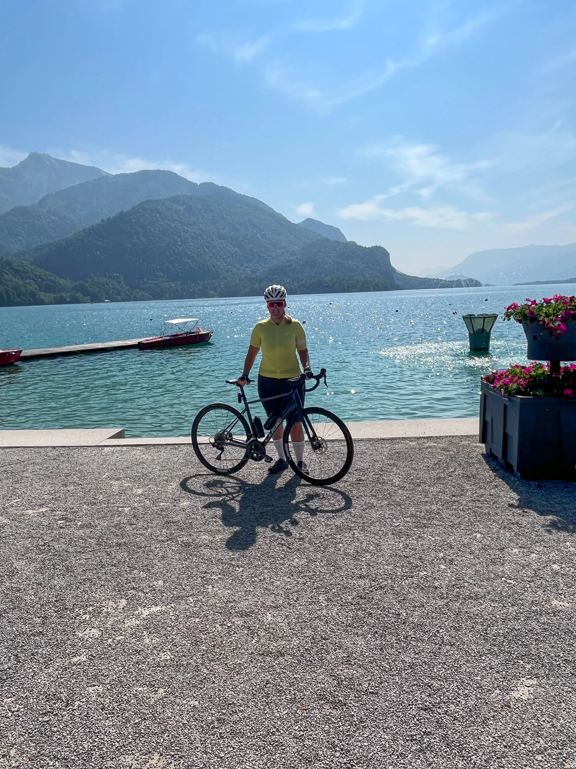 Drei Seen, eine Gravelrunde: Die 3-Seen-Tour ab Fuschl Fahrradfahrer am See mit Bergen im Hintergrund und klarem Himmel
