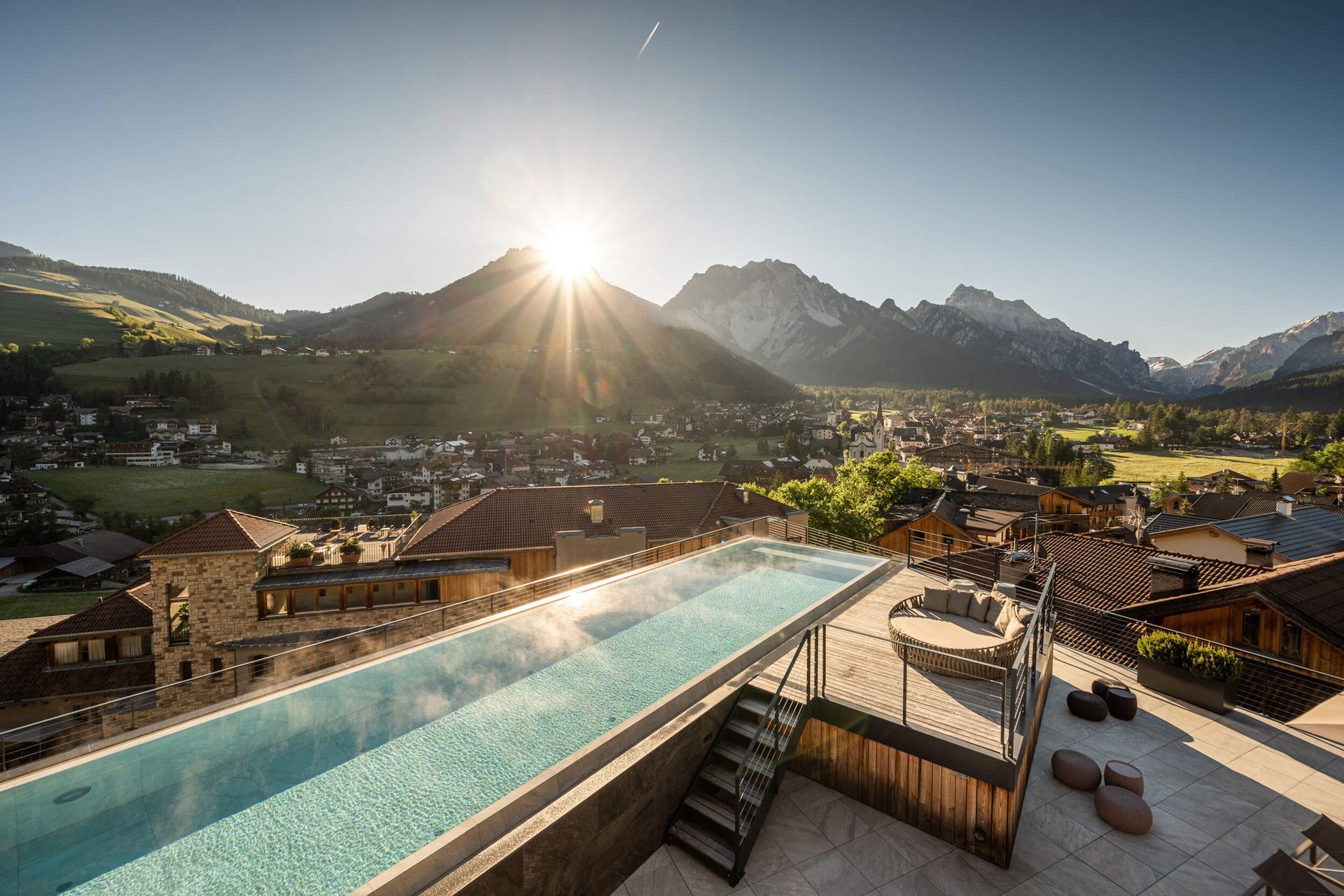 Sunrise over mountain village with heated pool on terrace