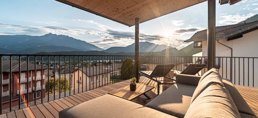 Terrasse mit Sofa und Liegestühlen mit Bergblick bei Sonnenuntergang