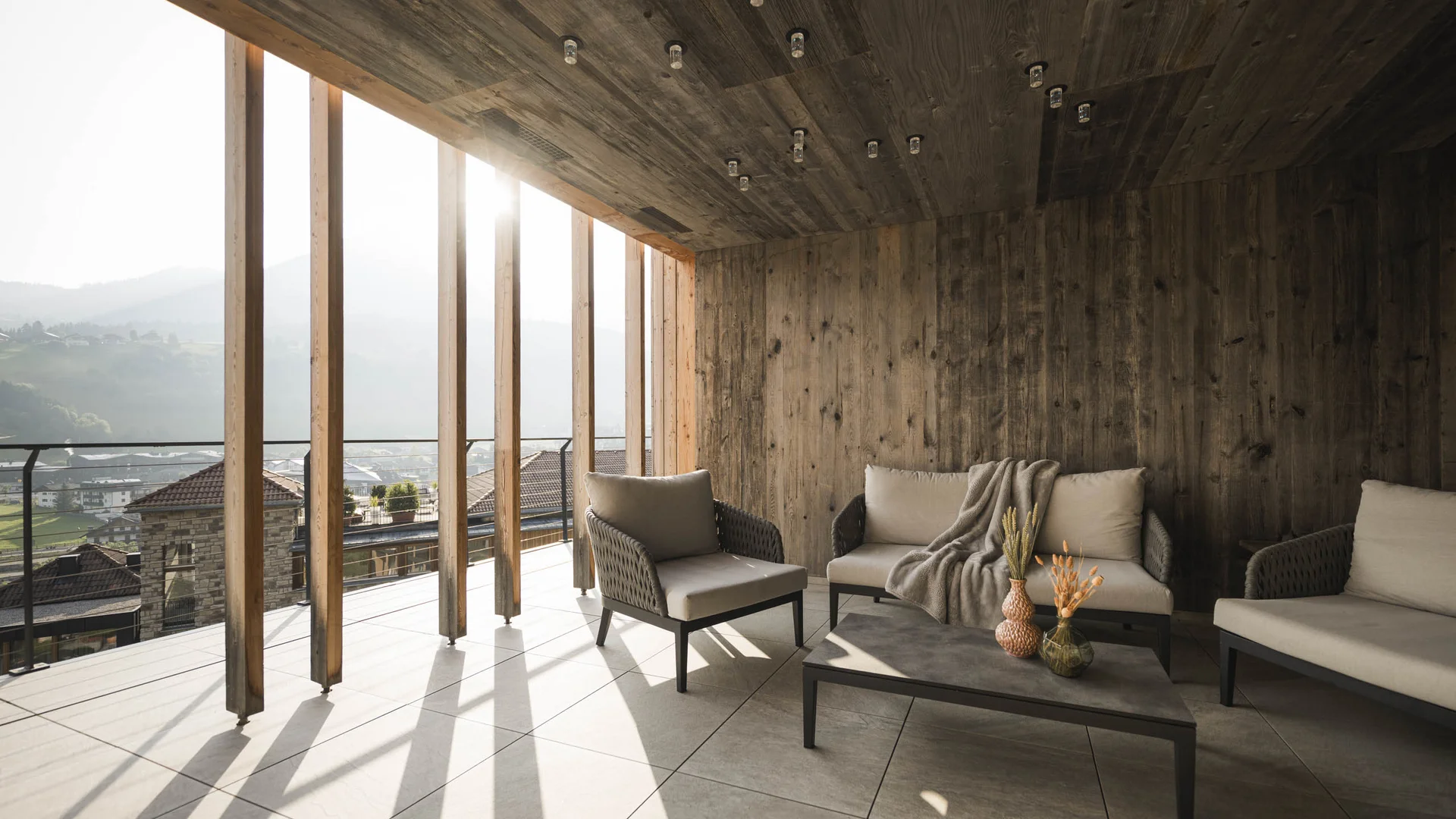 Herbst auf Schotter im Excelsior Dolomites Life Resort****s © Hannes Niederkofler Gemütliche Lounge mit Holzwänden und großen Fenstern mit Bergblick