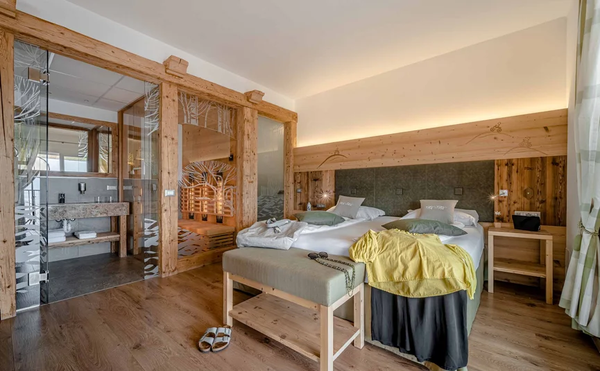 Cristallo Sport & Wellness Hotel **** © Andrea Acler Cozy hotel room with wood accents, double bed, and private sauna