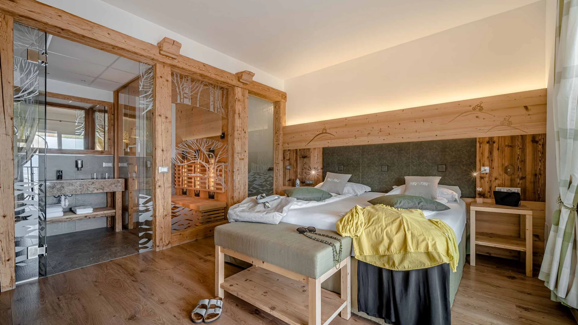 Gemütliches Hotelzimmer mit Holzakzenten, Doppelbett und privater Sauna