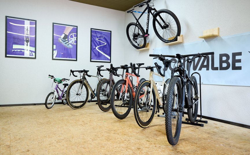 Mehrere Fahrräder in einem Raum, einige an der Wand hängend