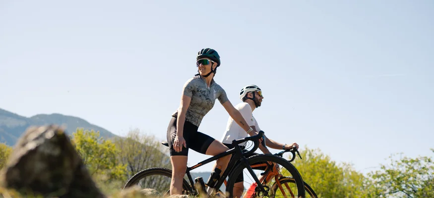 Auf Schotterkurs im Hotel Teutschhaus © Cinemepic / Teutschhaus Zwei Radfahrer in Sportkleidung fahren bei klarem Himmel durch die Natur